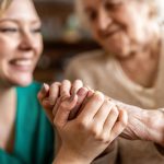 Cropped shot of a senior woman holding hands with a nurse
